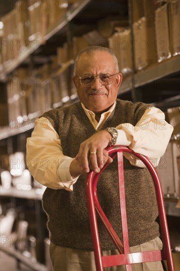 Mixed race man with hand truck in warehouse