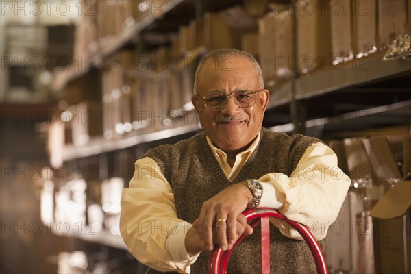 Mixed race man with hand truck in warehouse