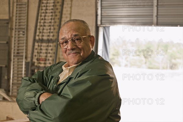 Mixed race man with arms crossed in warehouse