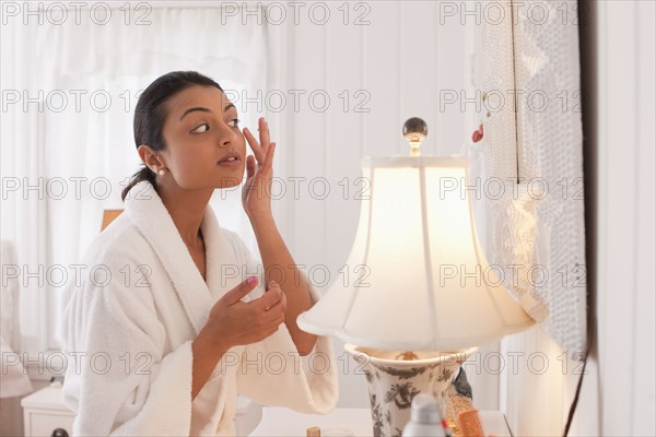 Middle Eastern woman applying lotion