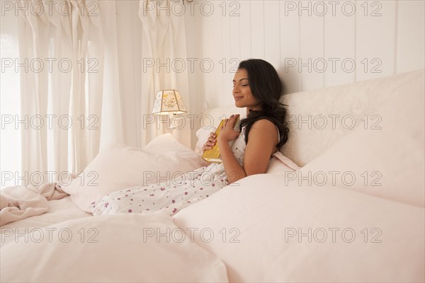 Middle Eastern woman reading in bed