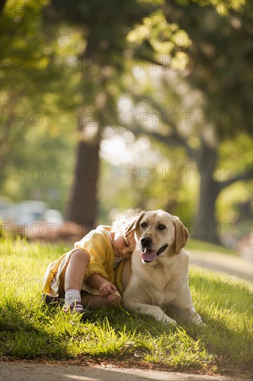 Caucasian girl playing with dog in yard