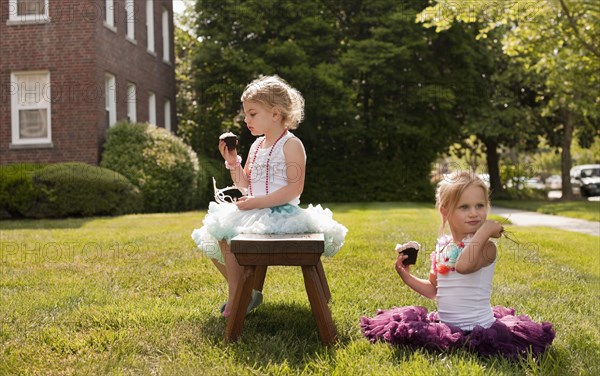 Caucasian girls playing dress up in yard