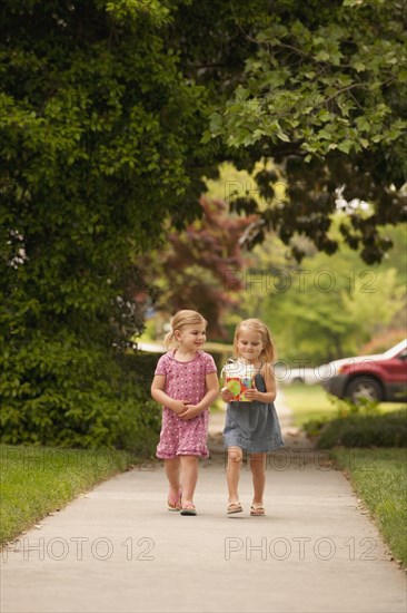 Caucasian girl walking on sidewalk with gift