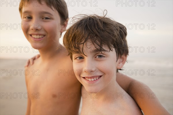 Caucasian boys walking on beach