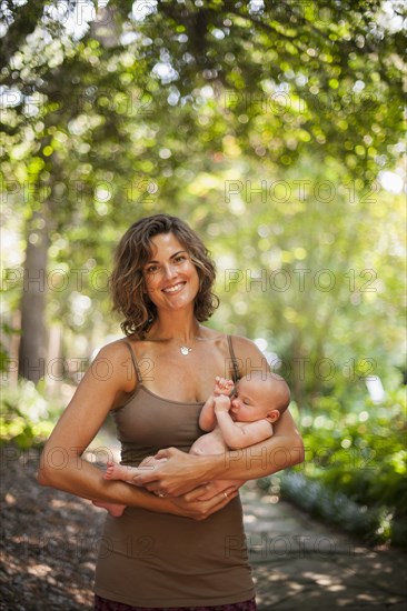 Caucasian mother holding baby outdoors