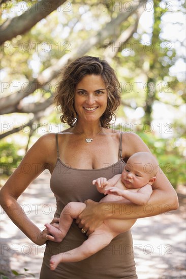 Caucasian mother holding baby outdoors