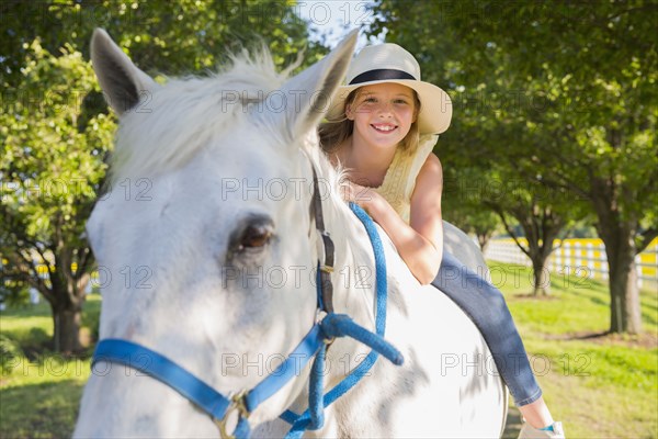 Caucasian girl riding horse on dirt path