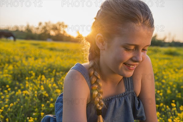 Caucasian girl smiling in field of flowers