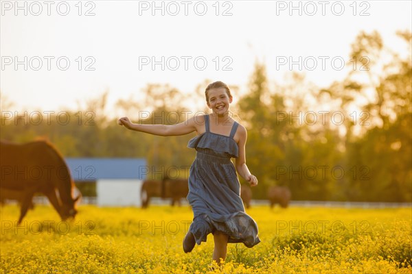 Caucasian girl running in field of flowers