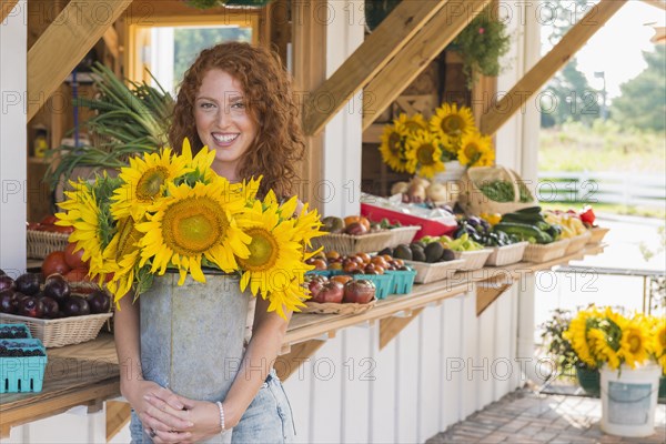 Caucasian woman holding sunflowers at farmers market