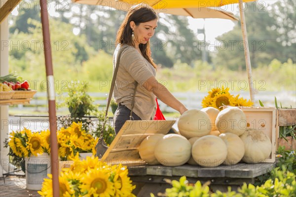 Hispanic woman browsing fruit at farmers market