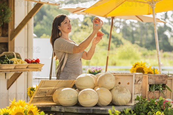 Hispanic woman browsing fruit at farmers market