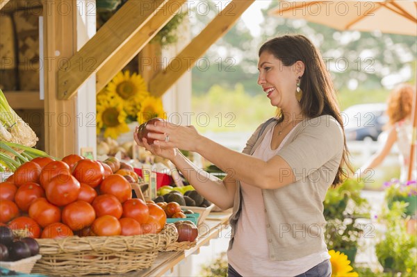 Hispanic woman browsing fruit at farmers market