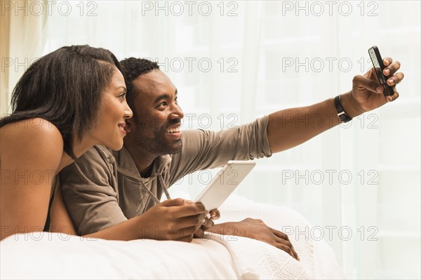 Couple taking selfie on bed