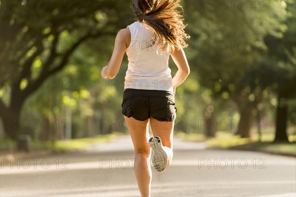 Caucasian woman jogging on neighborhood street