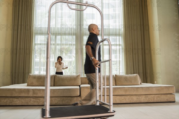 Bellhop pulling cart in hotel lobby