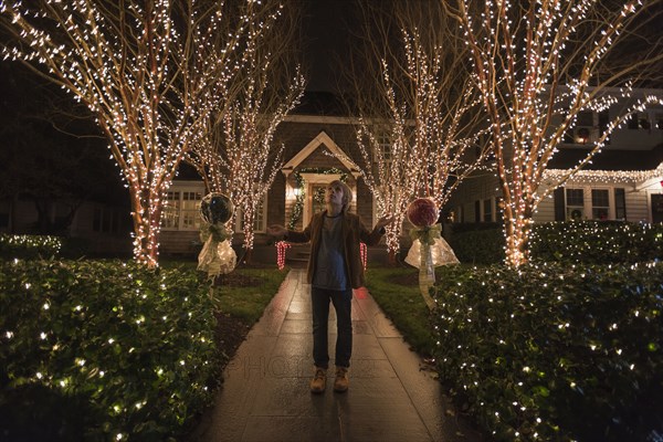 Caucasian boy admiring Christmas decorations in yard