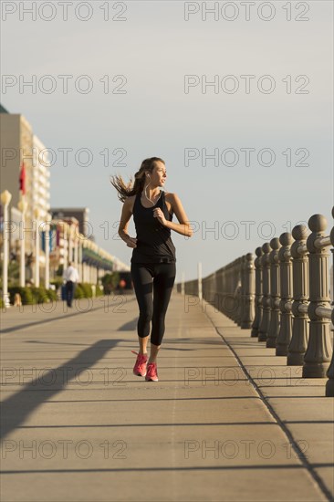 Caucasian teenage girl running on boardwalk