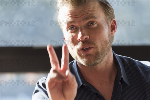 Caucasian man gesturing with fingers