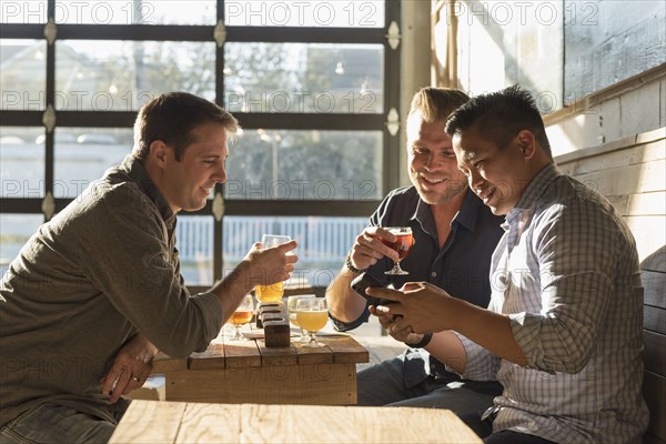 Friends texting on cell phone in brew pub