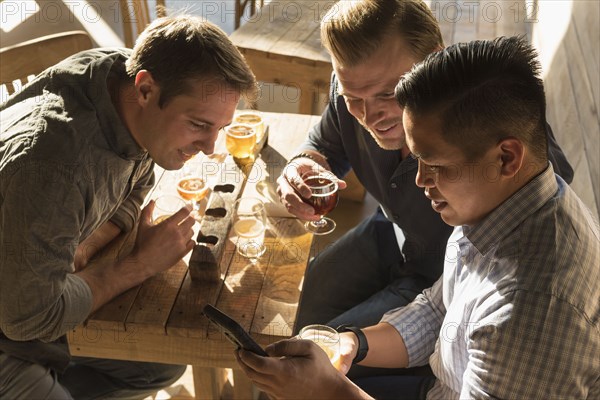 Friends texting on cell phone in brew pub