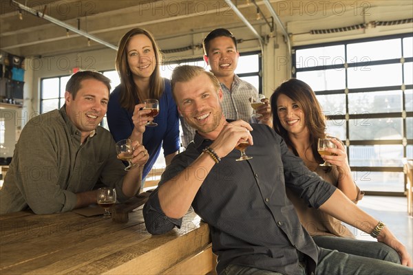 Portrait of smiling friends drinking beer in brew pub