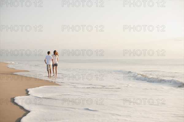 Caucasian brother and sister walking on beach