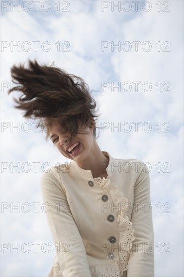 Mixed race girl flipping hair outdoors