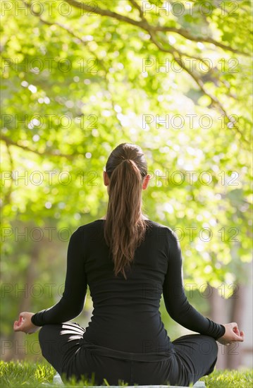 Caucasian woman practicing yoga in park