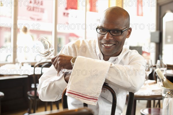 African American waiter sitting in restaurant