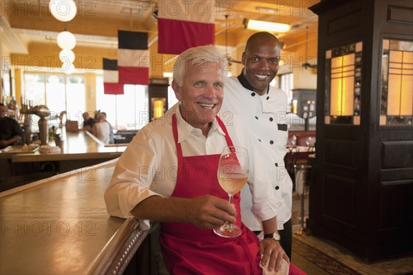 Smiling restaurant waiter and chef