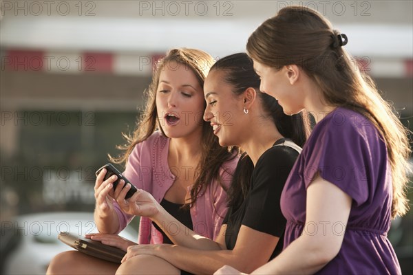 Woman showing cell phone to friends