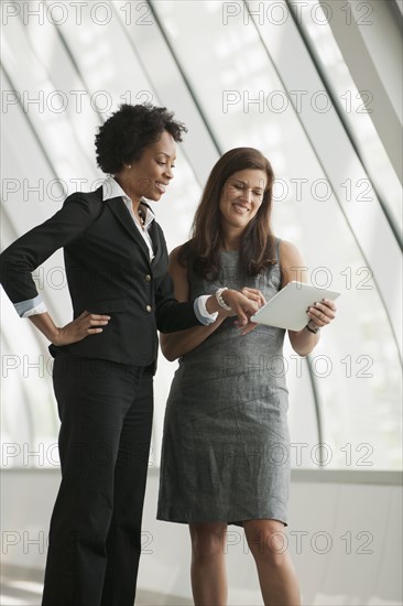 Businesswomen using digital tablet together