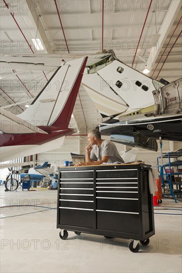 Caucasian man working in airplane hangar