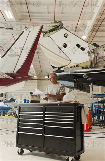 Caucasian man working in airplane hangar