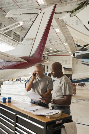 Men working in airplane hangar