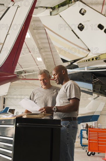 Men working in airplane hangar