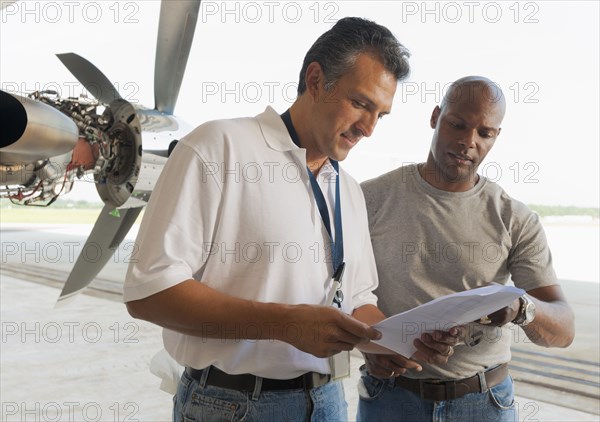 Men working in airplane hangar