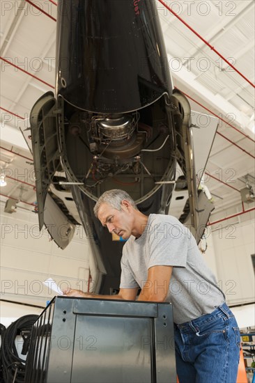 Caucasian man working in airplane hangar