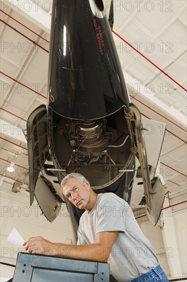 Caucasian man working in airplane hangar