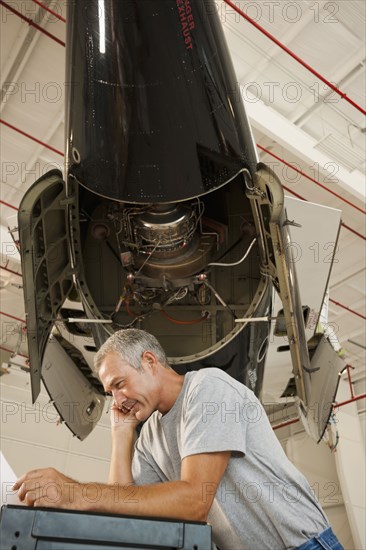 Caucasian man working in airplane hangar