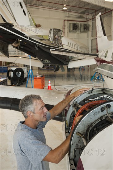 Caucasian man working in airplane hangar