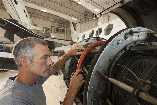 Caucasian man working in airplane hangar