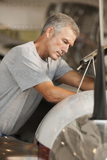 Caucasian man working in airplane hangar