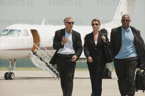 Business people walking on airport tarmac