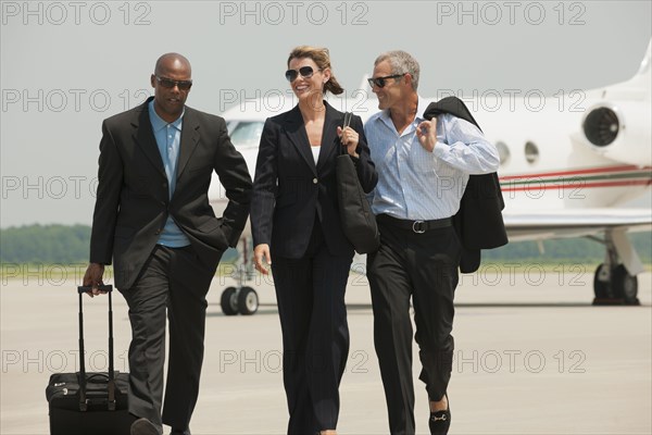 Business people walking on airport tarmac