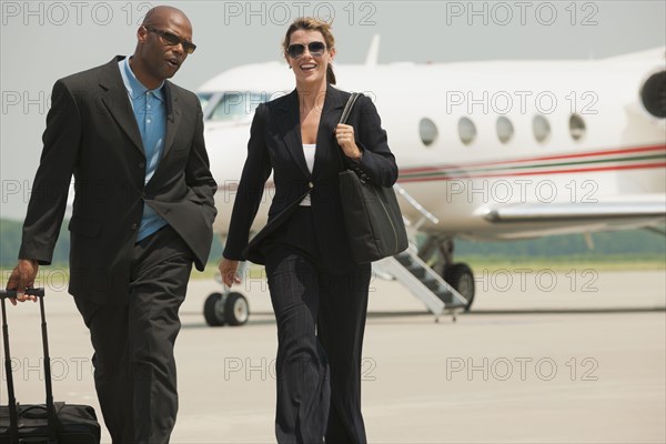 Business people walking on airport tarmac