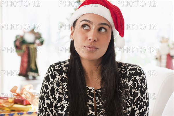 Hispanic woman wearing Santa hat
