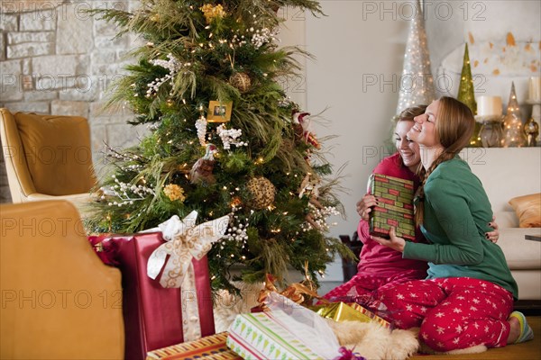 Caucasian women exchanging Christmas gifts